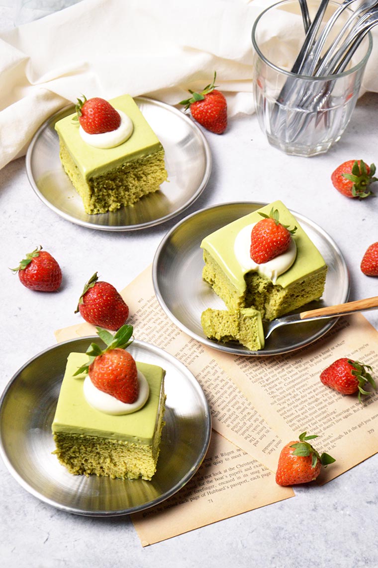 matcha tres leches cake with whipped cream and fresh strawberries